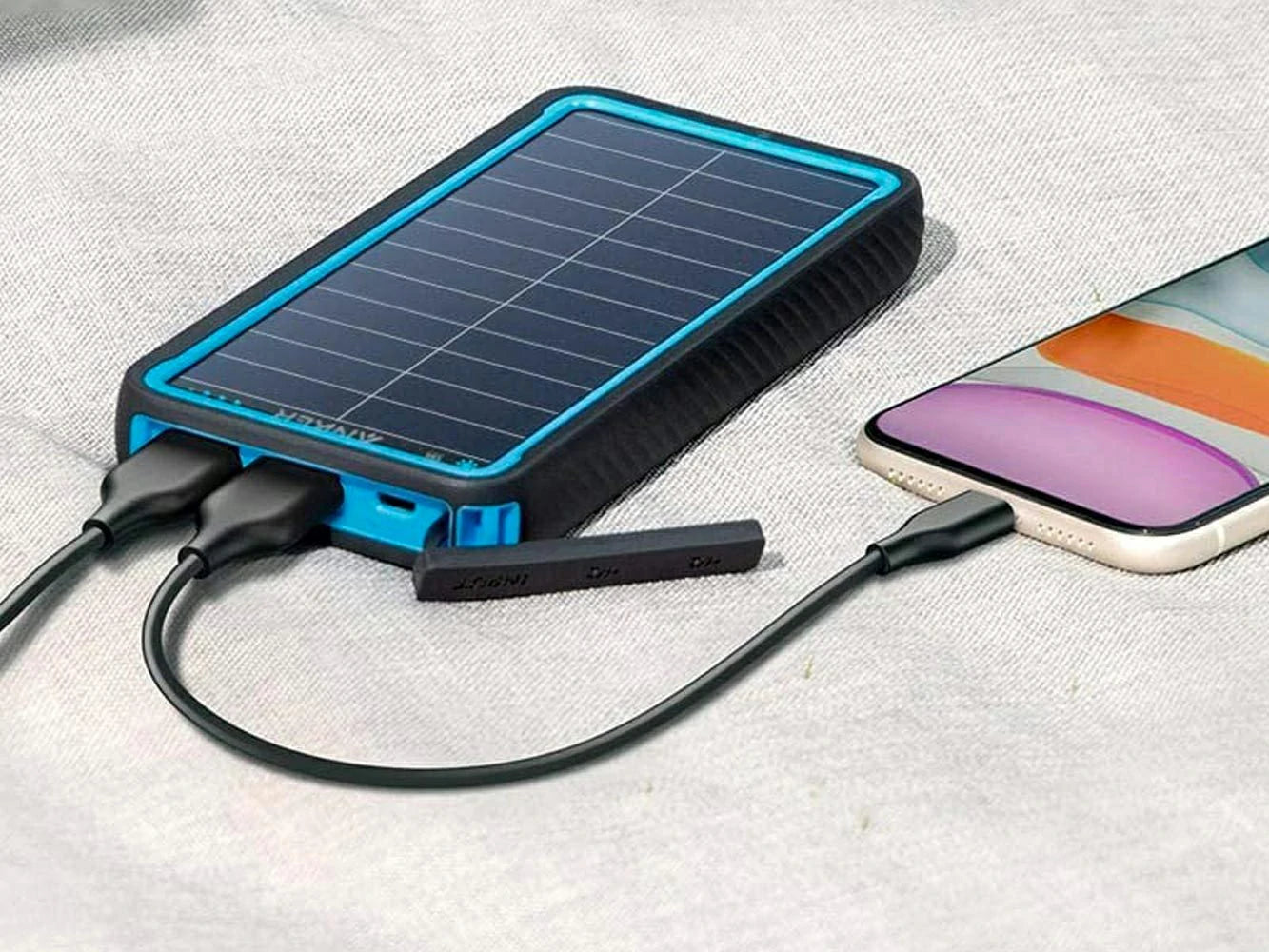 Solar-powered phone charger with a smartphone on a light fabric background