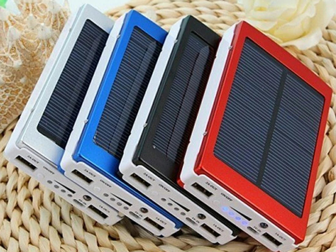 Four solar power banks in different colors on a woven surface